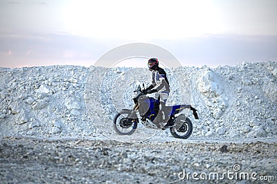 The biker rides enduro in a kaolin quarry Stock Photo