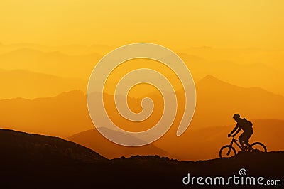 Biker riding on mountain silhouettes background Stock Photo