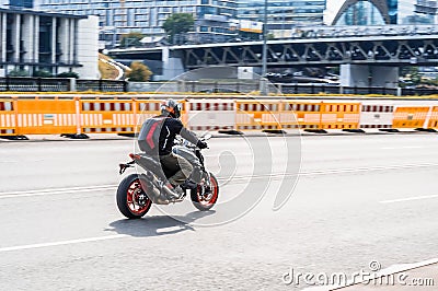 Biker on a sportbike in motion on city road. Man on the motorbike driving on high speed Editorial Stock Photo