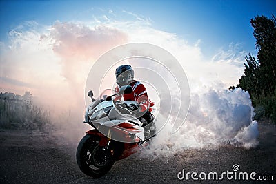 Biker staying on bike road with smoke of the tire, burn out in the moto show. the Sunset Stock Photo