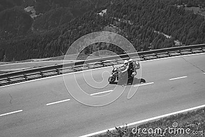 Bikers in mountain road in action ride, traveling across Europe, motorcycle tour, curve highway in mountains, copy space, extreme Stock Photo