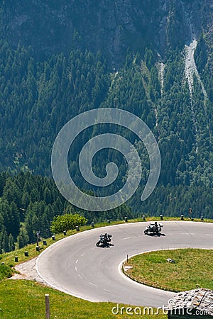 Bikers in mountain road in action ride, traveling across Europe, motorcycle tour, curve highway in mountains, copy space, extreme Stock Photo
