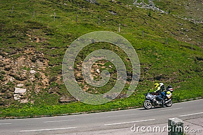 Bikers in mountain road in action ride, traveling across Europe, motorcycle tour, curve highway in mountains, copy space, extreme Stock Photo