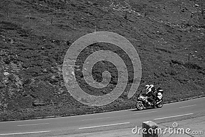 Bikers in mountain road in action ride, traveling across Europe, motorcycle tour, curve highway in mountains, copy space, extreme Stock Photo