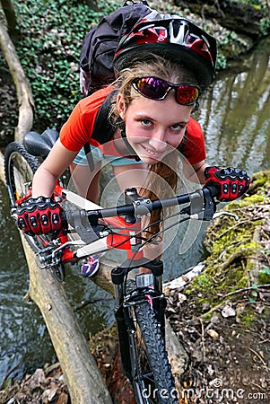 Bikes girl cycling fording throught water . Stock Photo