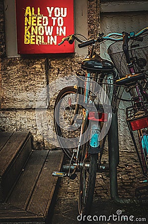 bikes parked in front of an advertising sign for berlin, Editorial Stock Photo
