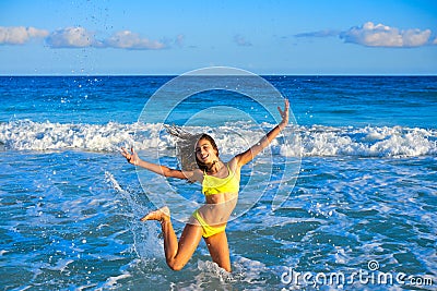 Bikini girl jumping in Caribbean sunset beach Stock Photo