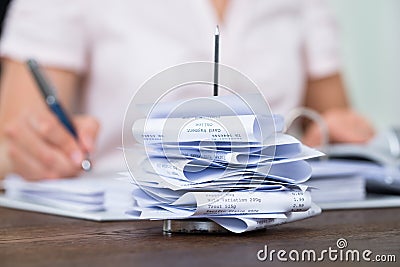 Bills In Paper Nail With Businessperson At Desk Stock Photo