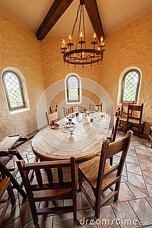 Chairs around an oblong wooden table in castle-like room.. Editorial Stock Photo