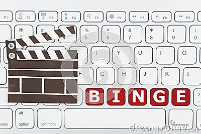 Binge watching movies online with a keyboard and movie clapper Stock Photo