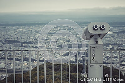 Binocular or telescope locate on Mount Moiwa for support traveler use looking for view of Sapporo City. Stock Photo