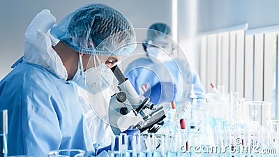 Biochemical research scientist team working with microscope for coronavirus vaccine development in pharmaceutical research Stock Photo