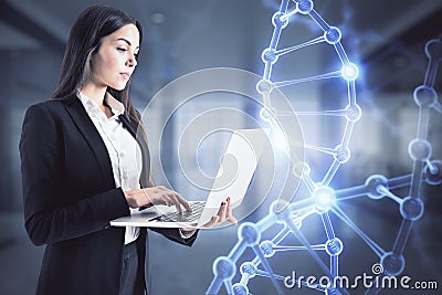 Bioengineering concept with businesswoman working on laptop and hologram DNA strand Stock Photo