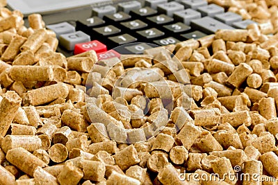 Biofuels, Eco-friendly fuel . Alternative biofuel from sawdust for burning in furnaces. Wood pellets and calculator Stock Photo