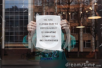 Biohazard concept of living in a new reality of coronavirus epidemy hysteria cafÃ© owner sticks advertisement on quarantine Stock Photo