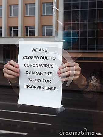 Biohazard concept of living in a new reality of coronavirus epidemy hysteria cafÃ© owner sticks advertisement on quarantine Stock Photo