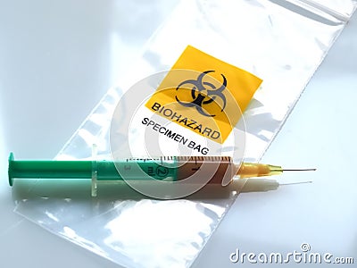 Biohazard specimen bag with a syringe and brown liquid Stock Photo
