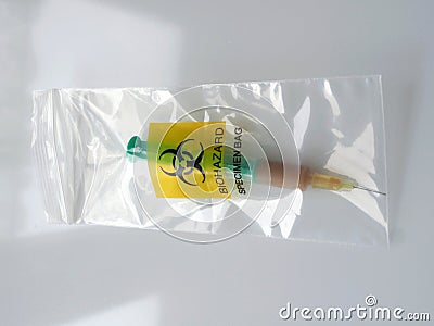 Biohazard specimen bag with a syringe and brown liquid Stock Photo