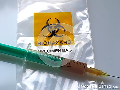 Biohazard specimen bag with a syringe and brown liquid Stock Photo