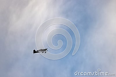 biplane flying high up in the sky against a sunset Stock Photo