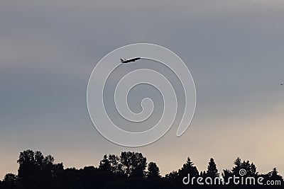 biplane flying high up in the sky against a sunset Stock Photo