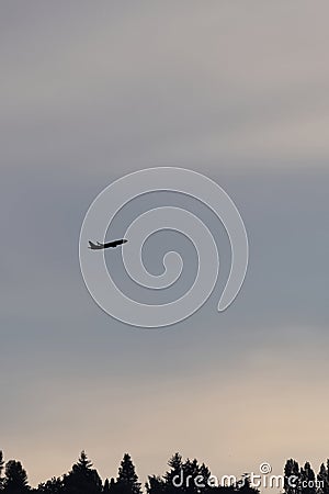 biplane flying high up in the sky against a sunset Stock Photo