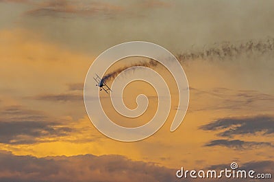 Biplane flying at sunset. Stock Photo