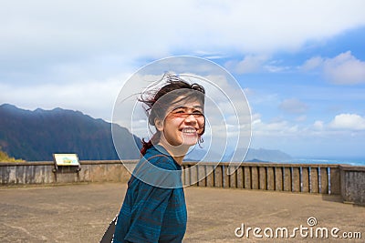 Teen girl standing at Pali Lookout on hot sunny day Stock Photo