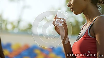 Biracial girl drinking after workout, restoring water balance, hydration Stock Photo