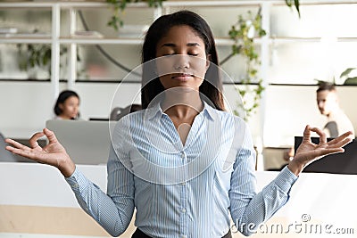 Biracial woman office worker take break during meditating avoid stress Stock Photo