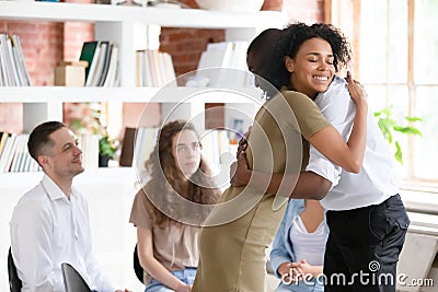 Woman psychologist addiction counsellor hugging supporting guy at group session Stock Photo