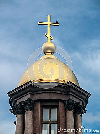 Golden dome of the chapel with a bird at the top of the cross Stock Photo