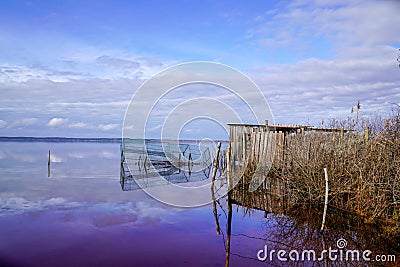 Bird duck hunting trap in the morning at wild sunrise over a calm rural lake pond Stock Photo