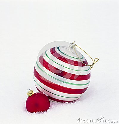 Birght, shiny red and green glass Christmas ornaments baubles decorations on white snow background Stock Photo