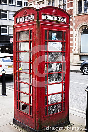 BIRMINGHAM, UK - March 2018 Rusty and Weathered Red Vintage Telephone Booth Standing in the City Street. Common London Editorial Stock Photo