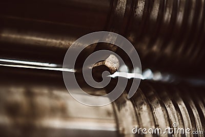 Birth of detail. Woman goldsmith creating metal detail on craft rolling machine Stock Photo