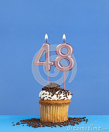Birthday candle with cupcake on blue background - Number 48 Stock Photo