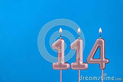 Birthday card with number 114 - Burning anniversary candle on blue background Stock Photo