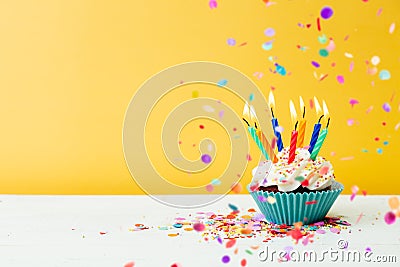 Birthday cupcakes with confetti on yellow background Stock Photo