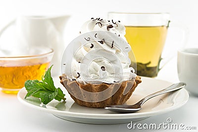Birthday cupcake with mint on plate with cup of tea. Selective f Stock Photo
