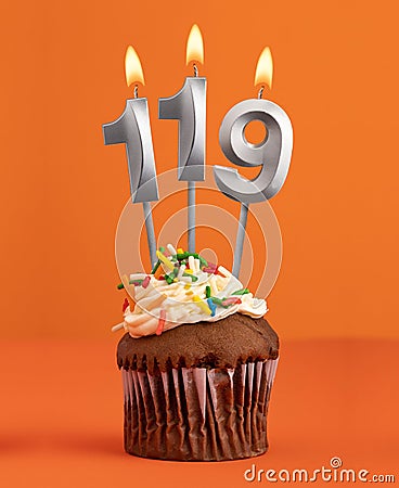 Birthday cupcake with number 119 candle - Orange color background Stock Photo