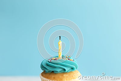 Birthday greeting concept. Blown out candle on muffin, cupcake. Blue background Stock Photo