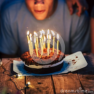 Birthday and party event by night concept - cake and candles on a wooden table - unrecognizable people ready to blow the fire and Stock Photo