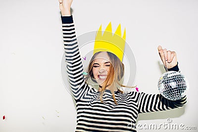 Birthday party, new year carnival. Young smiling woman on white background celebrating brightful event, wears stripped Stock Photo