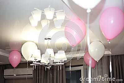 Birthday pink balloons under the ceiling at home Stock Photo