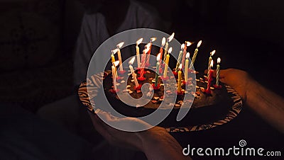 Birthday surprise cake with candles in darkness Stock Photo