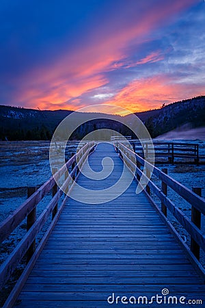 Biscuit basin walkway with blue steamy water and beautiful colorful sunset. Yellowstone, Wyoming Stock Photo