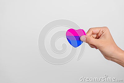 Bisexuality Celebrate Day and LGBT pride month, LGBTQ+ or LGBTQIA+ concept. Hand holding purple, pink and blue heart shape for Stock Photo