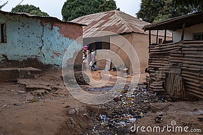 Children playing in front of their home, in a slum with an open air sewer, at in the city of Bissau Editorial Stock Photo