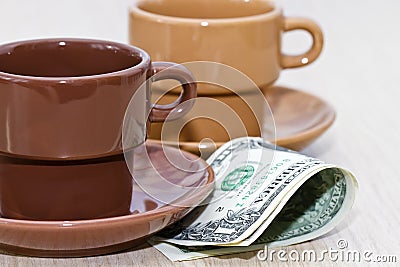 Bit of cash lying under an empty coffee Cup Stock Photo